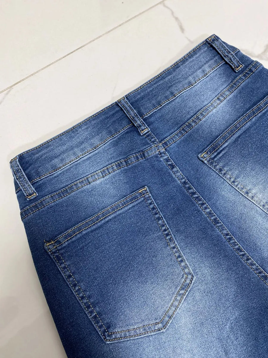 Close-up of blue denim jeans on a white surface