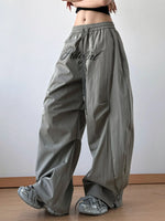 Person wearing gray wide-leg pants with 'PrettyGirl' text on a plain background