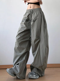 Person wearing gray wide-leg pants with 'PrettyGirl' text on a plain background