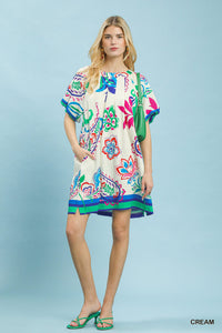 Woman wearing a colorful patterned dress on a light blue background