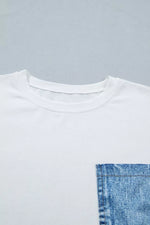 White t-shirt with a blue denim pocket on a gray background