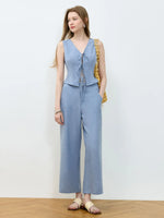 Woman wearing a light blue jumpsuit with a white background