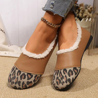 Brown shoes with leopard print soles and white fur trim worn by a person.