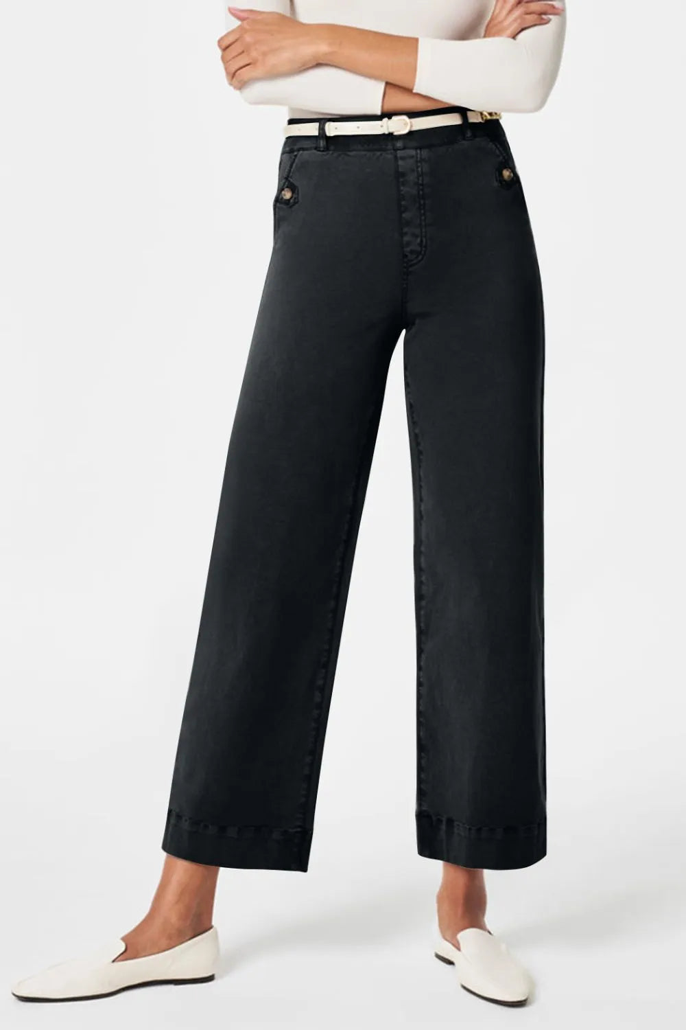 Person wearing black wide-leg pants on a white background