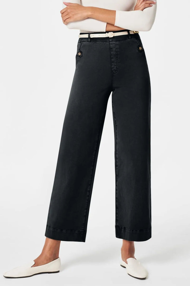 Person wearing black wide-leg pants on a white background