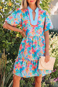 Woman wearing a colorful floral dress in an outdoor setting