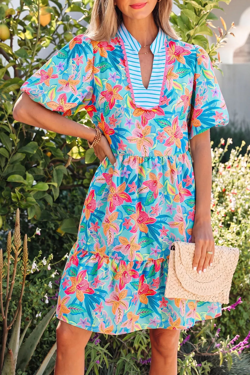 Woman wearing a colorful floral dress in an outdoor setting