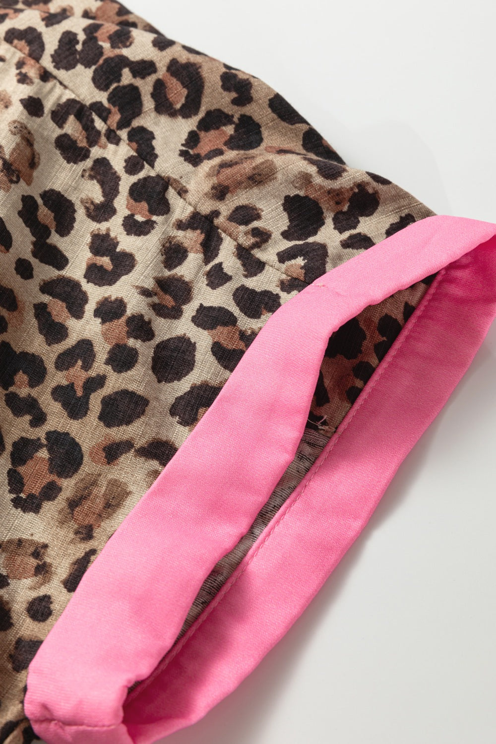 Leopard print fabric with a pink border on a white background