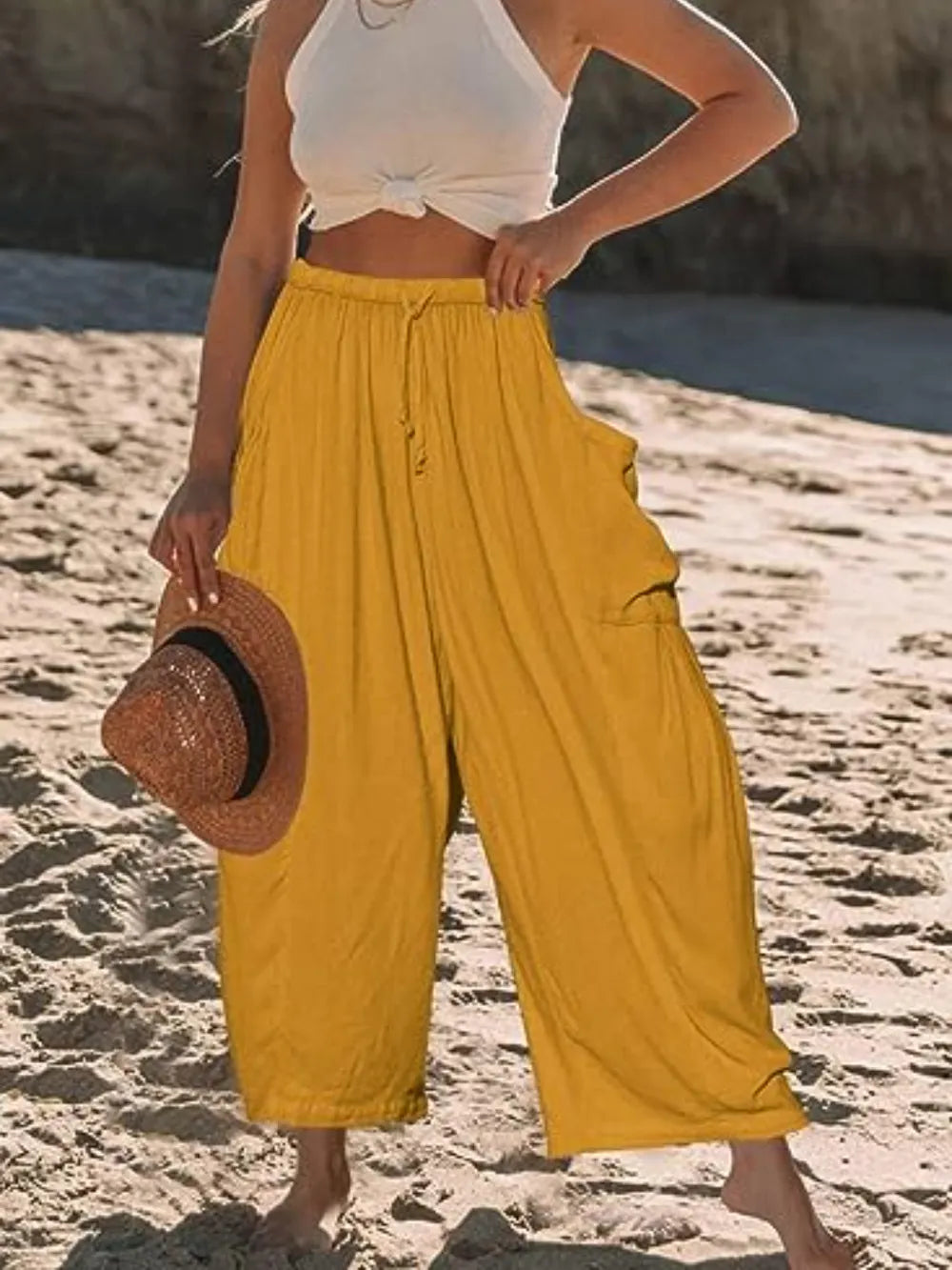 Woman on the beach wearing yellow pants