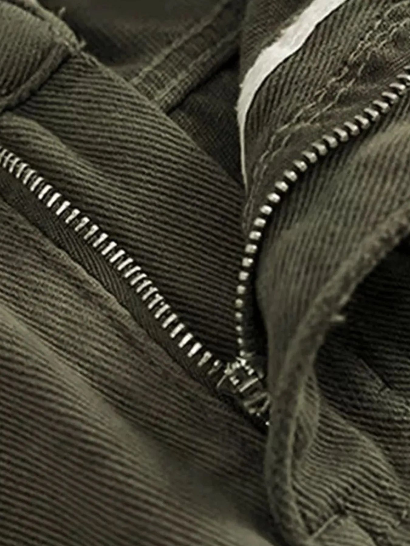 Close-up of a green corduroy jacket with a zipper