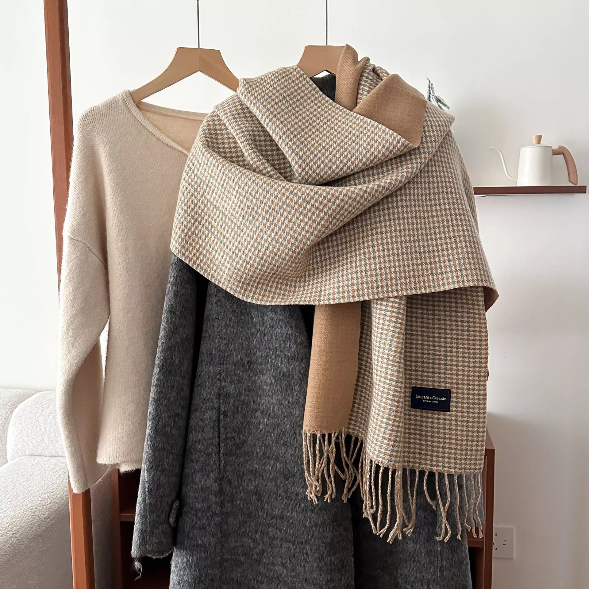 Plaid scarf draped over a coat with a neutral background