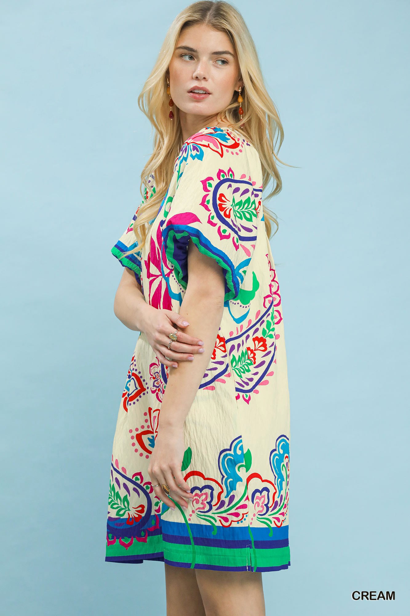 Woman wearing a colorful dress with a blue background