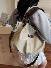 Person wearing a beige backpack with brown straps in an indoor setting
