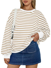 Woman wearing a striped long-sleeve top and denim skirt on a white background