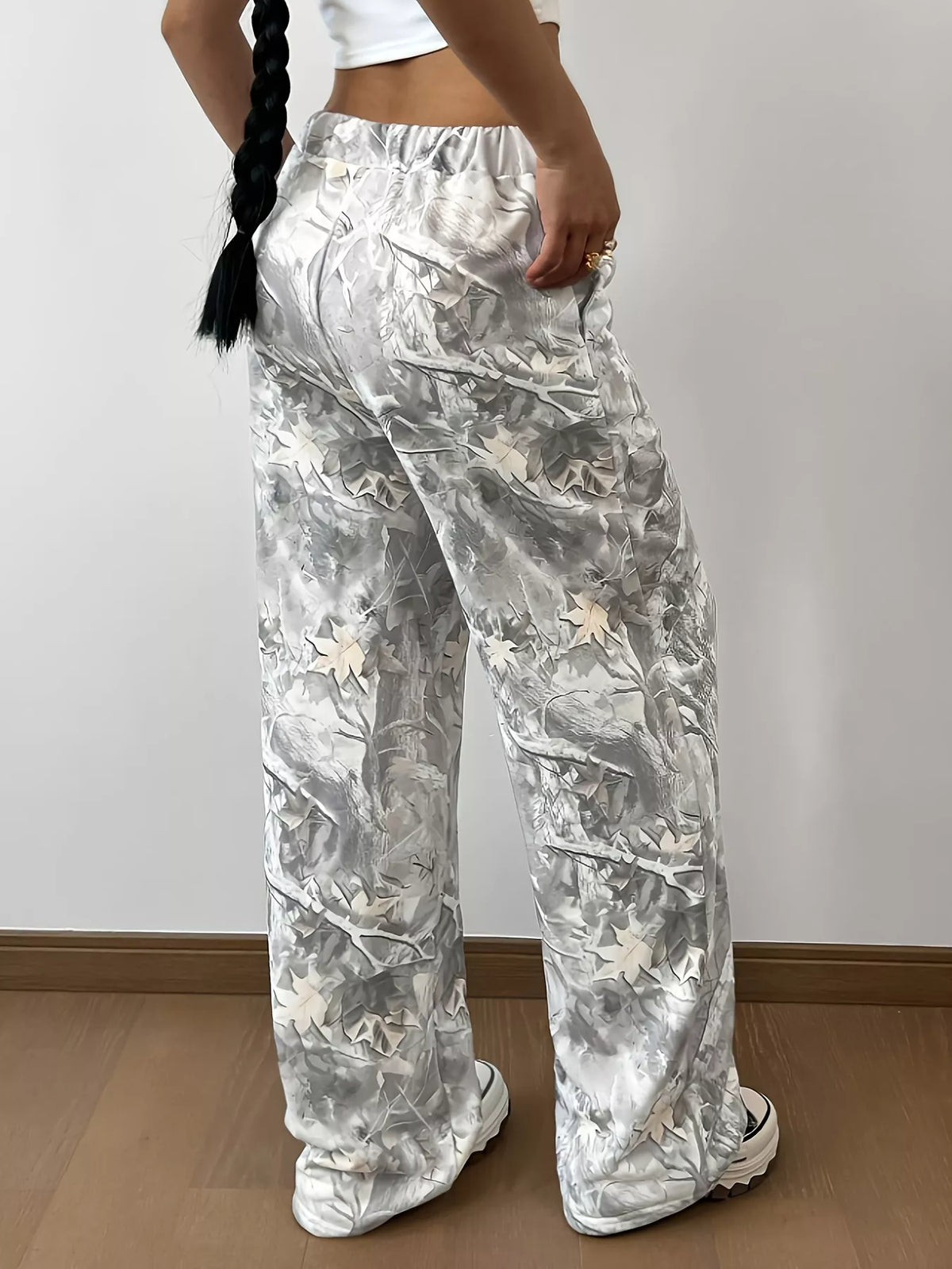 Person wearing floral-patterned pants against a plain background