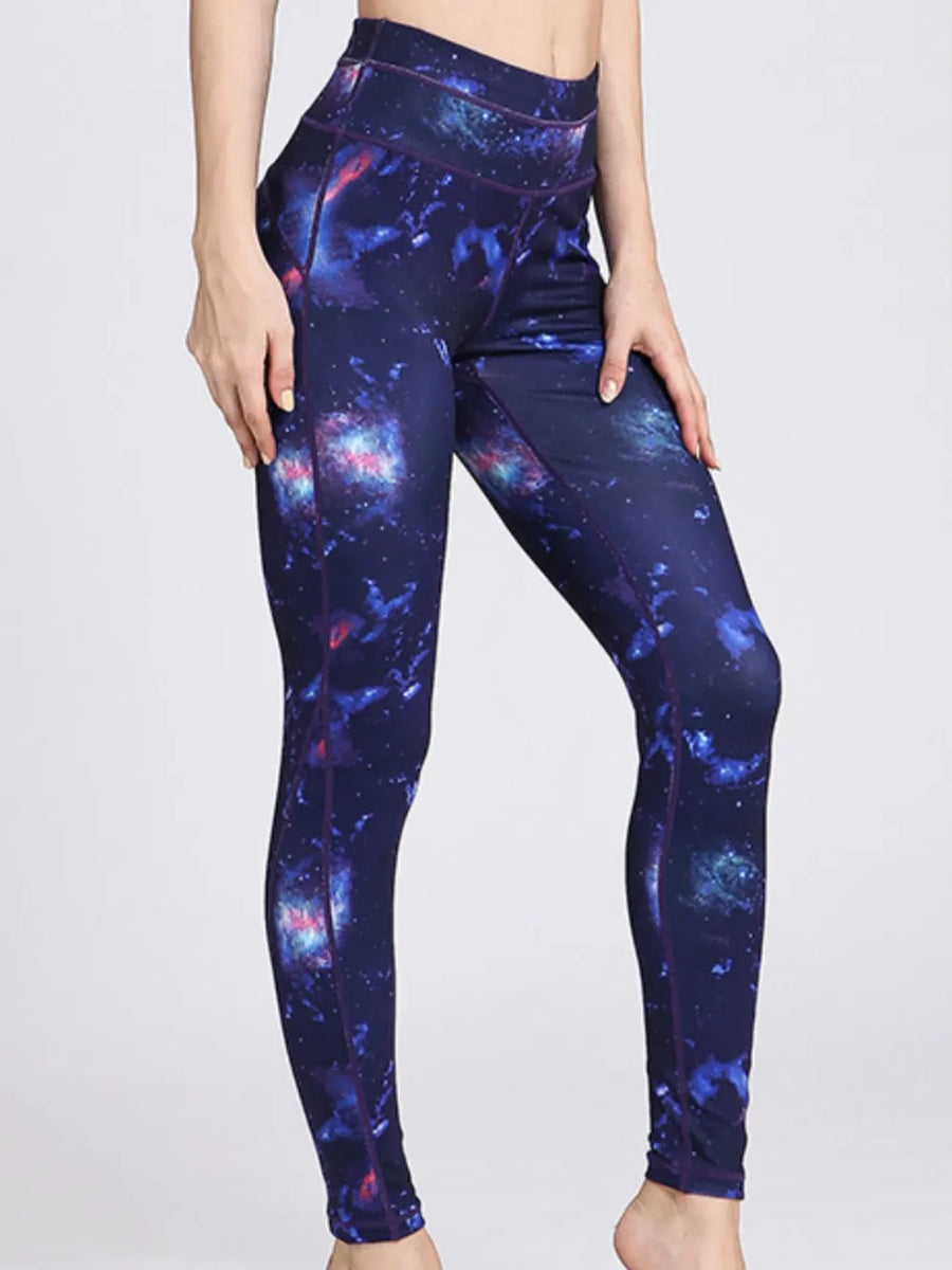 Galaxy-themed leggings worn by a person on a white background