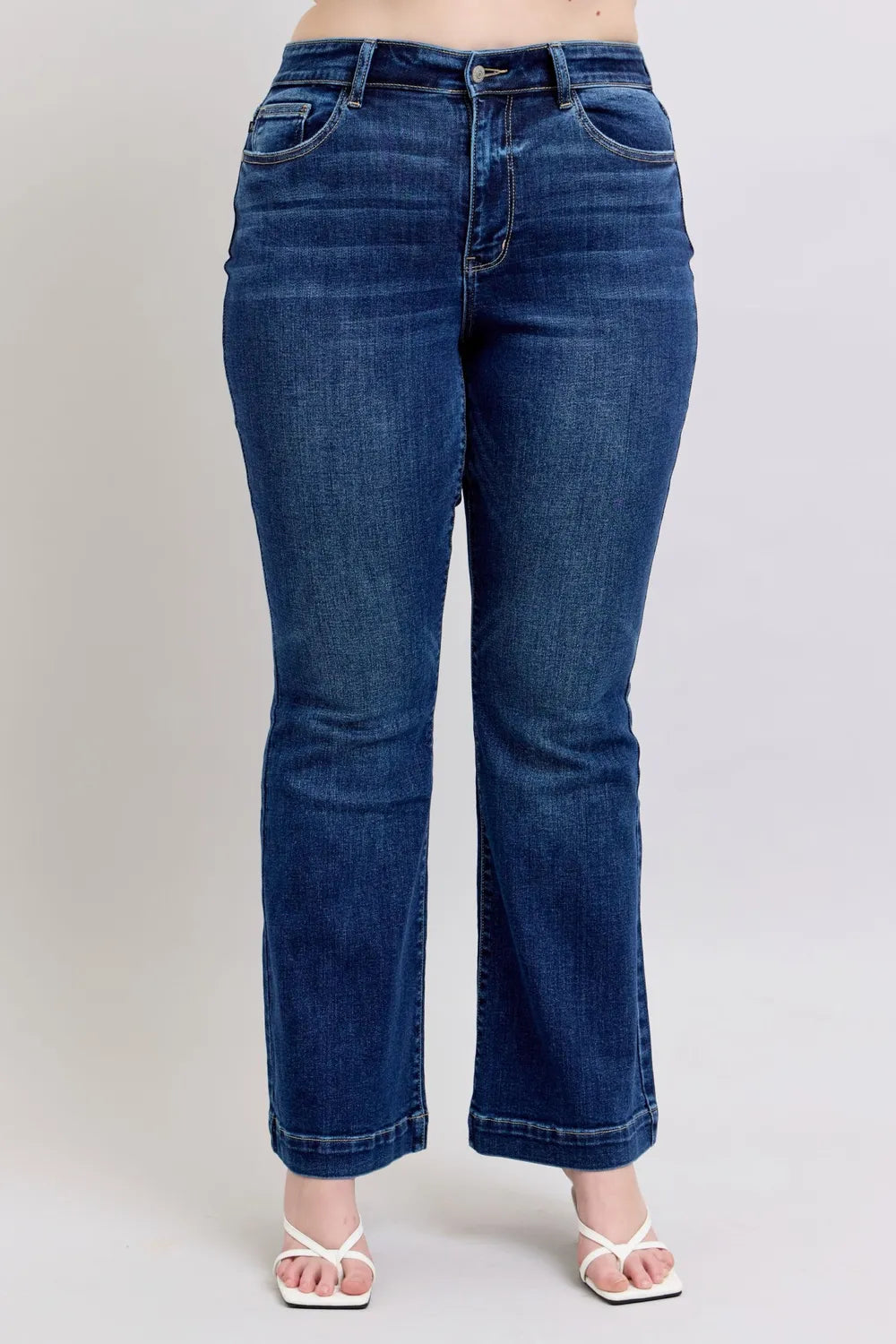 Blue jeans worn by a person on a plain background