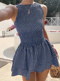 Person wearing a blue and white checkered dress outdoors.