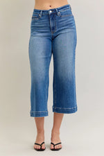Blue jeans worn by a person on a plain background