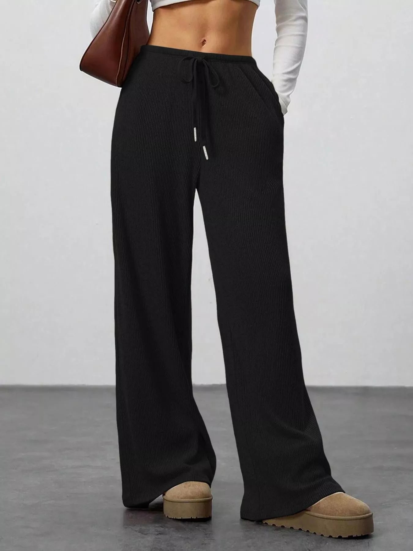 Black wide-leg pants worn by a person on a plain background