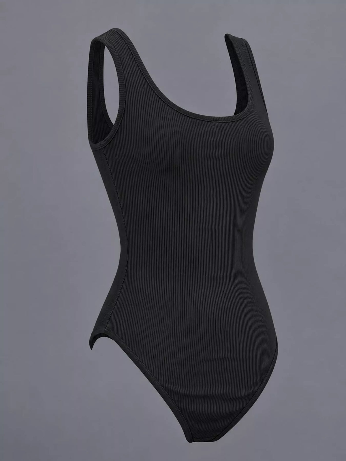 A black ribbed one-piece bodysuit with a scoop neckline and wide shoulder straps, displayed against a solid gray background.