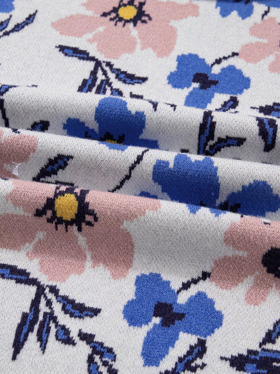 Close-up of floral fabric with pink, blue, and black flowers on a white background