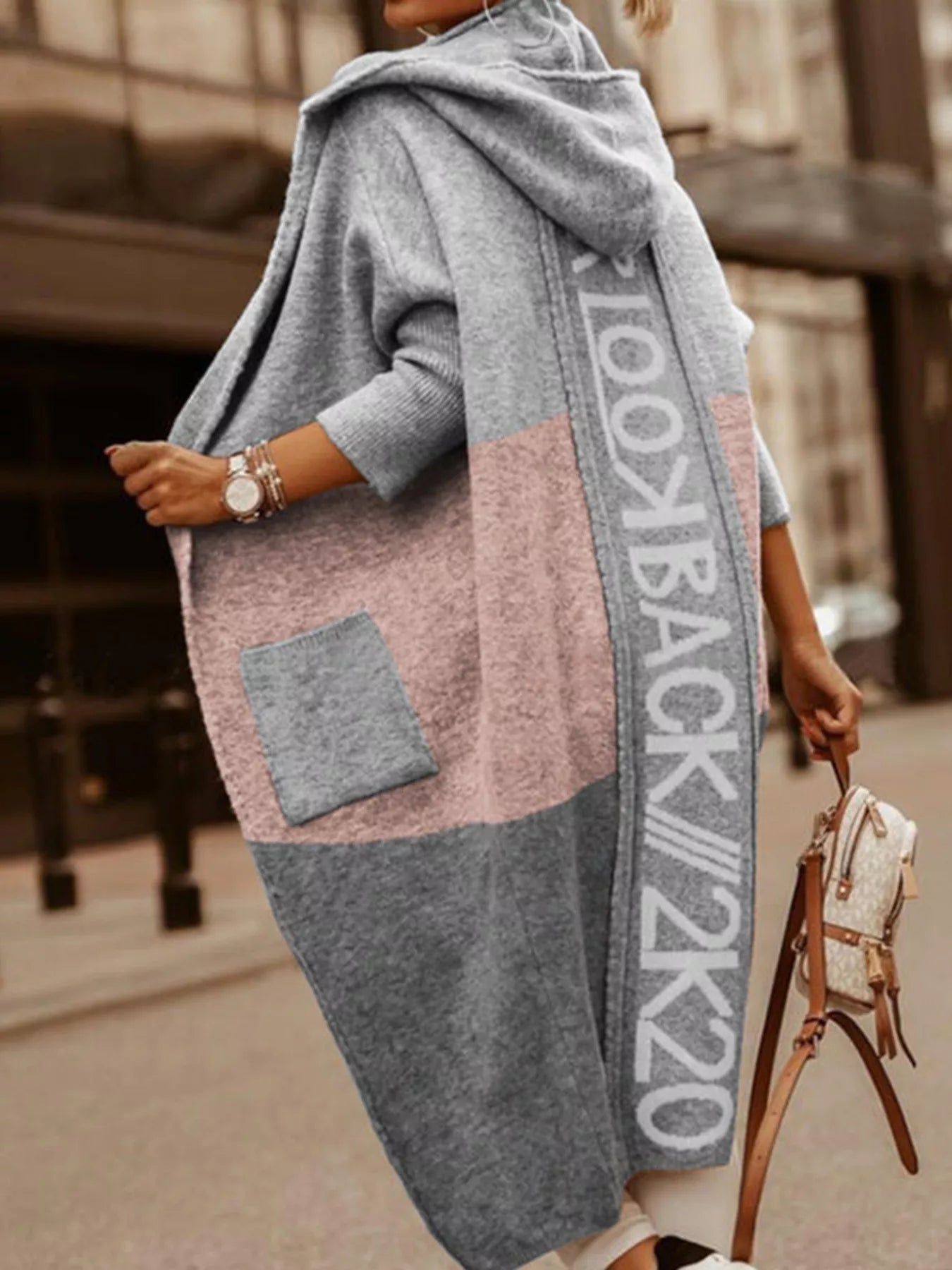 Person wearing a long, patterned scarf with text on a blurred street background