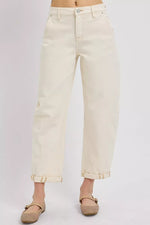 Beige jeans worn by a person on a light gray background