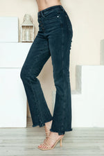 Person wearing dark blue jeans with a neutral background