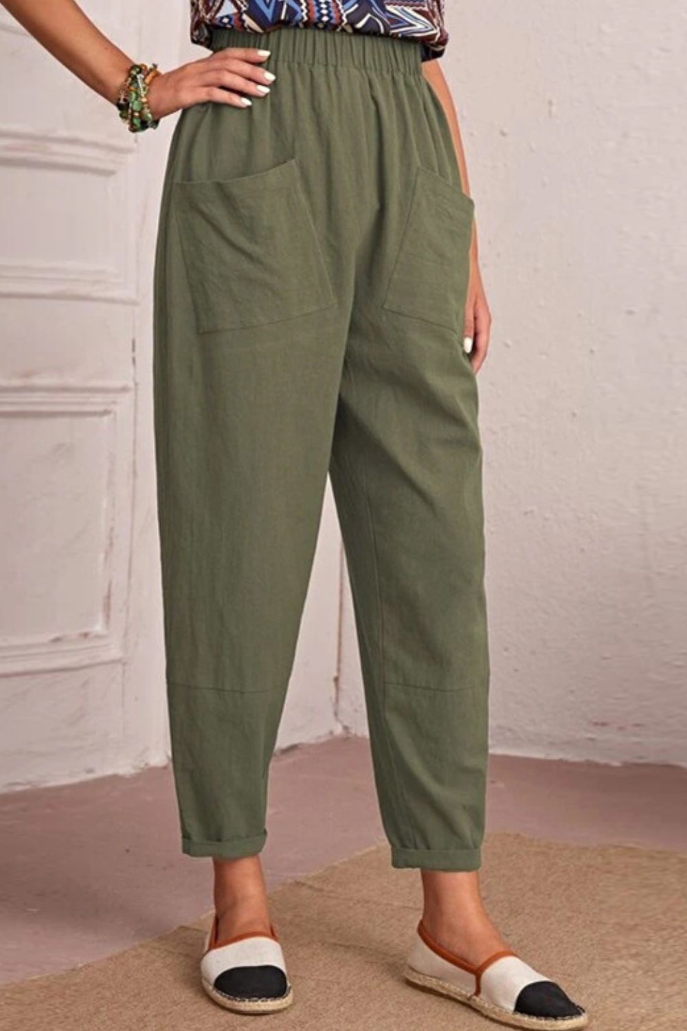 Person wearing green pants with a neutral background