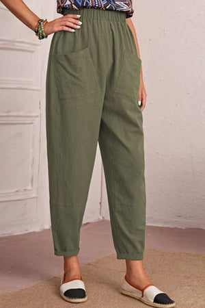 Person wearing green pants with a neutral background