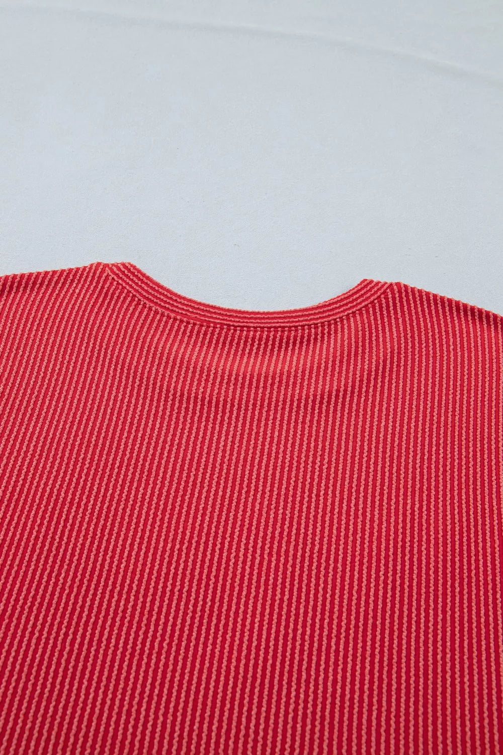 Close-up of a red textured fabric on a light gray background