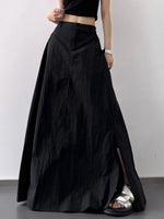 Person wearing a long black skirt with a plain background