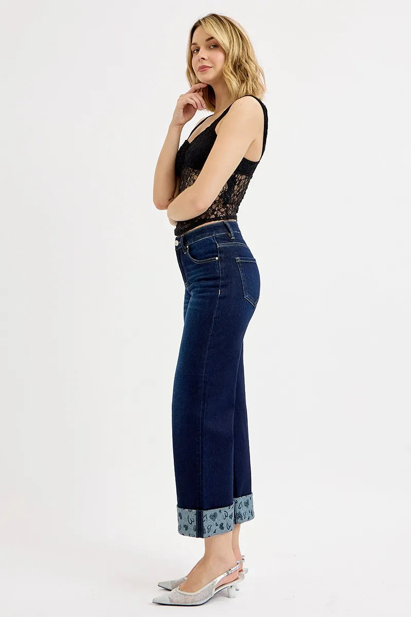 Woman wearing a black lace top and blue jeans on a white background