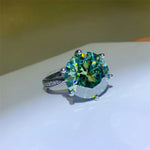 Ring with a large green gemstone on a white surface