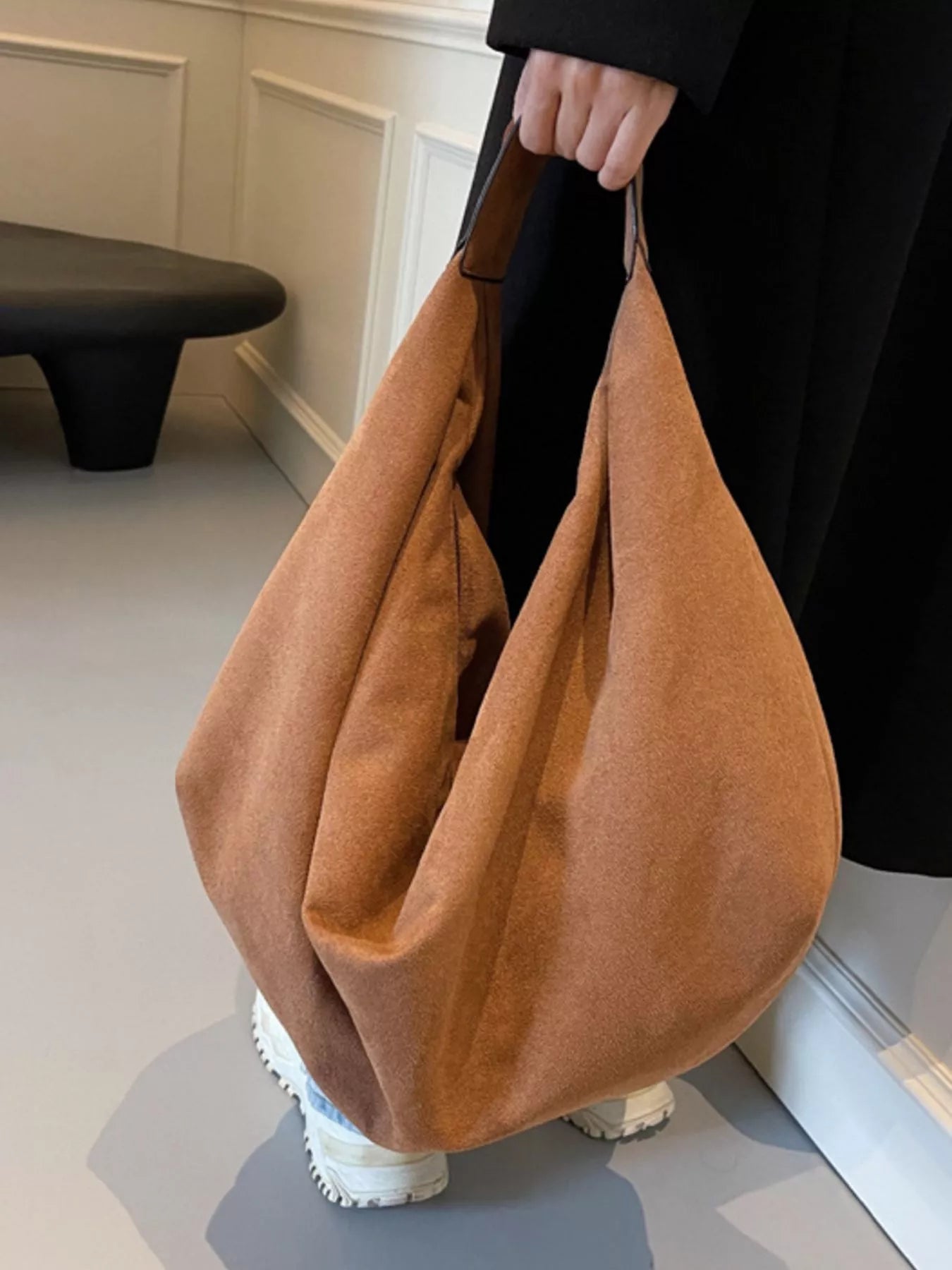 Person holding a brown bag indoors