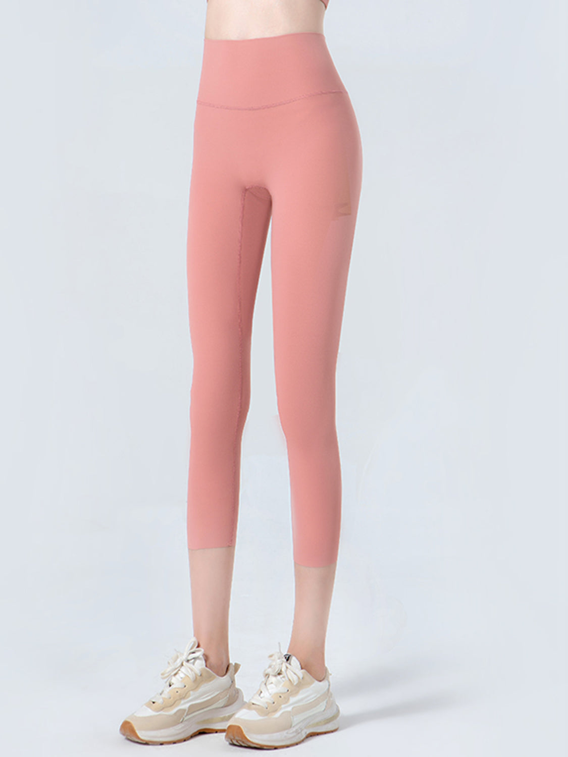 Person wearing pink leggings on a white background