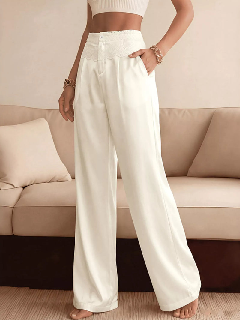 Person wearing white wide-leg pants standing in a living room.