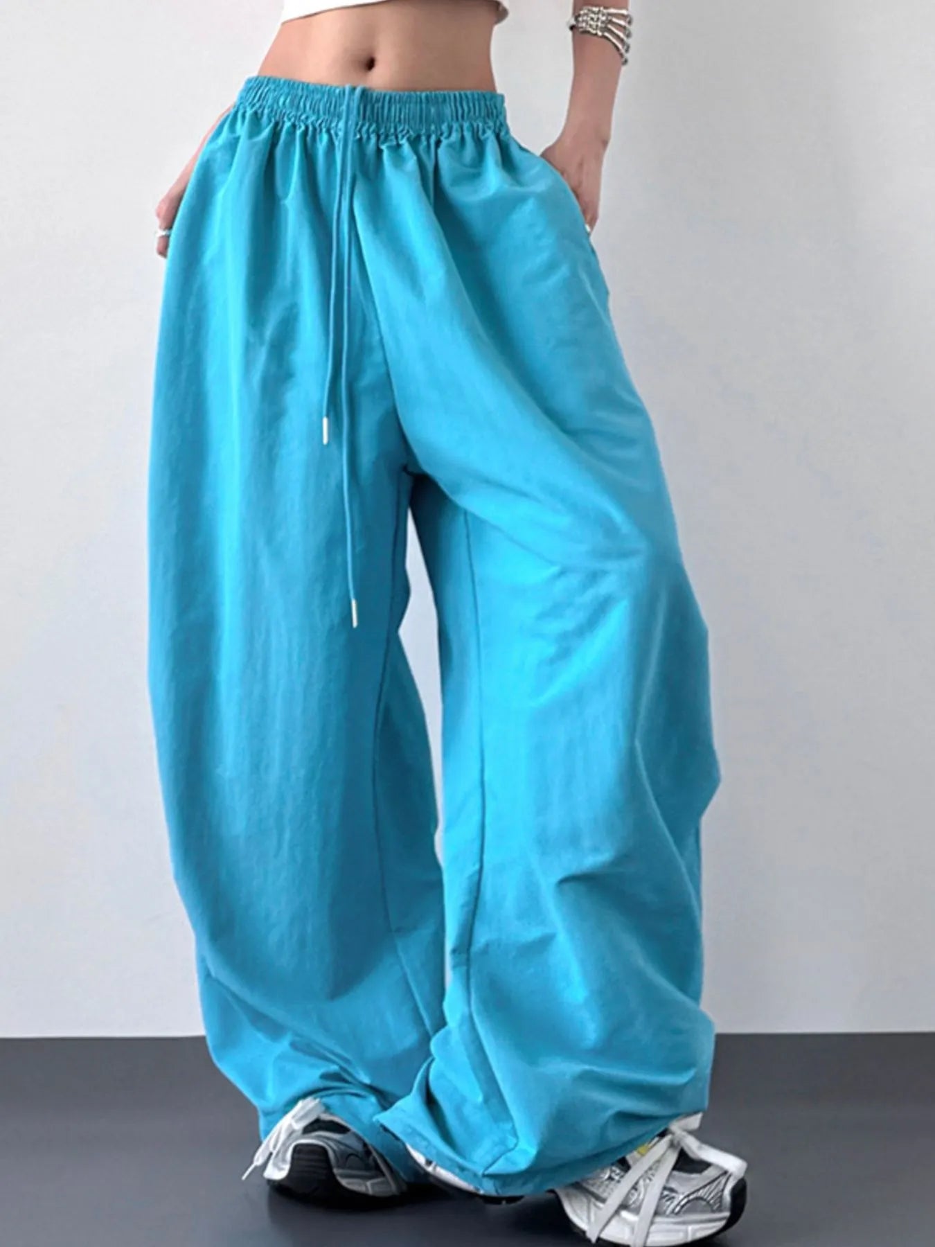 Turquoise wide-leg pants worn by a person on a plain background