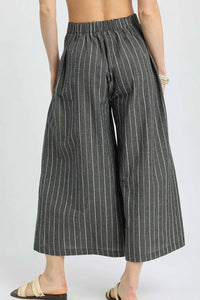 Pinstripe wide-leg pants worn by a person on a white background
