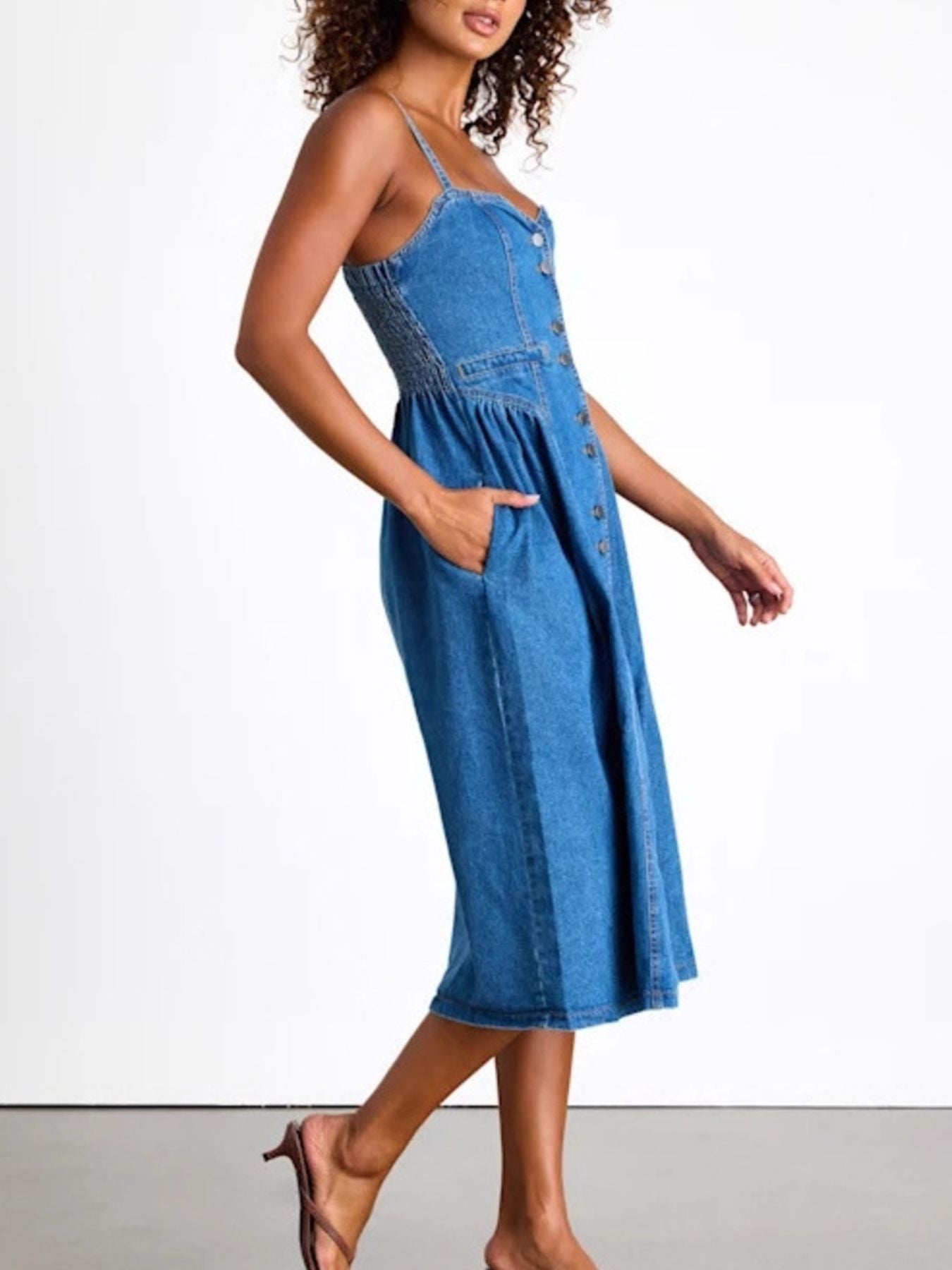 Woman wearing a blue denim dress on a white background