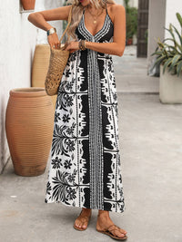 Woman wearing a black and white patterned dress standing outdoors.