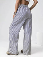 Person wearing black and white striped pants on a plain background