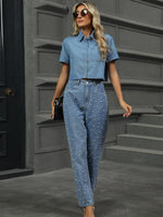 Woman in a denim outfit walking on a gray pavement.