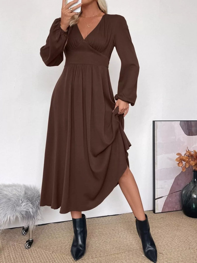 Woman wearing a brown dress with long sleeves in an indoor setting.