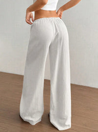 White wide-leg pants worn by a person on a plain background