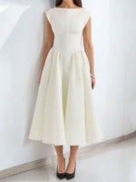 Woman wearing a white dress against a plain background