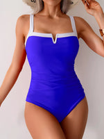 Blue swimsuit with white accents worn by a model against a neutral background