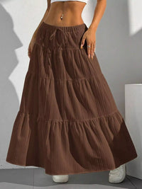 Brown tiered skirt worn by a person against a neutral background