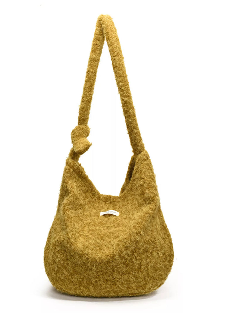 Yellow textured handbag with a handle on a white background